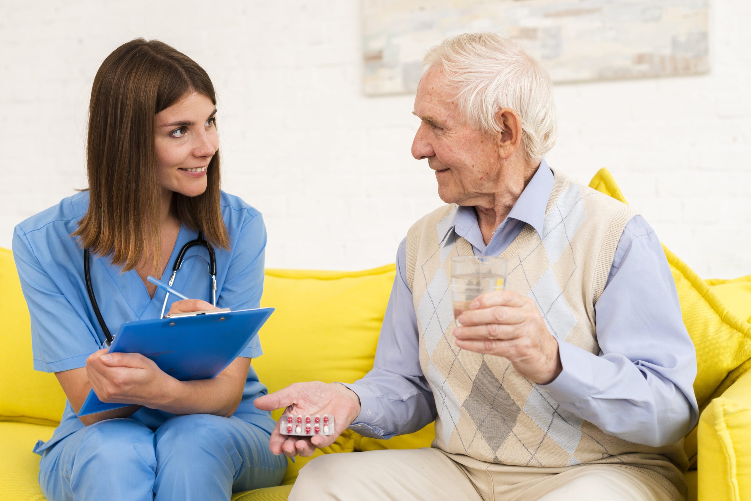 old-man-holding-his-pills-while-talking-nurse-min