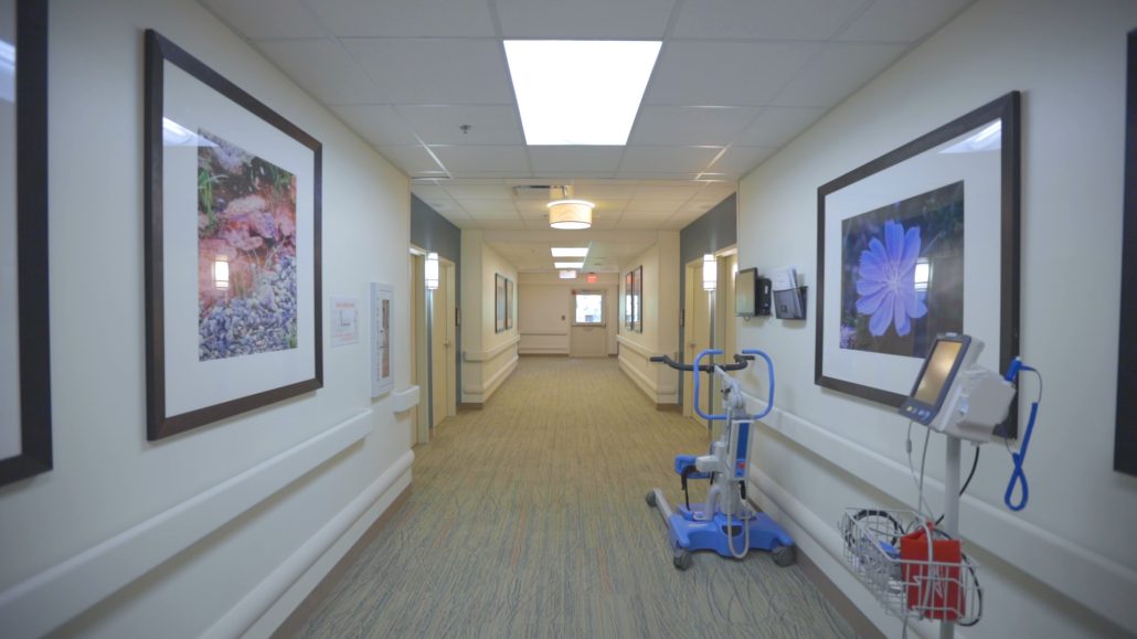 Hallway with picture frames on the wall and respiratory equipment on the side.
